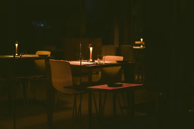 Gedeckte Tische im warmen Licht der Tischlampen am Abend