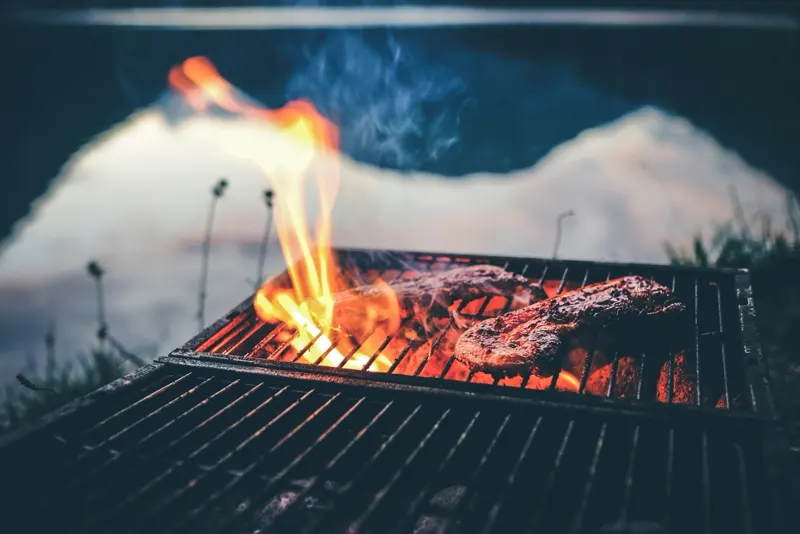 Offene Flammen schlagen durch den Grillrost